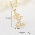 Photo macro du pendentif lettre X en or 18k avec couronne et zircons, mesurant 3,3 cm par 2,1 cm - Pendentif Couronne Lettre X Doré / Or