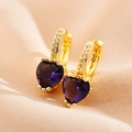 Macro detail of gold hoop earrings with purple heart-shaped crystals and zircon pave stones - Dark Blue