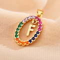 Macro detail of gold oval pendant with rainbow zircons and a central letter F - Letter F
