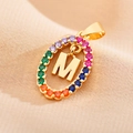 Detailed view of golden oval pendant with letter M and colorful zircon stones - Letter M