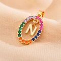 Macro shot of gold oval pendant featuring letter N and multi-color zircon stones - Letter N