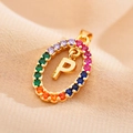 Macro shot of oval gold necklace pendant with rainbow zircon stones and letter P detail - Letter P