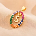 Detail of gold letter S pendant inlaid with colorful zircon on pink fabric texture - Letter S