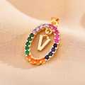 Detail of a gold letter V pendant with multi-colored crystals on soft fabric background - Letter V