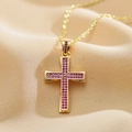 Close-up of gold cross pendant necklace featuring purple micro-pave cubic zirconia stones - Red