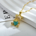 Detalle de colgante de oso dorado con circonitas micro-pavé y gema de corazón turquesa - Azul