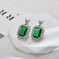 Close-up of emerald-cut green zircon earrings with shimmering halo in silver setting - Silver Green Stud Earrings