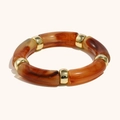 Retro amber textured resin bracelet with gold metal spacers on a white background - Amber