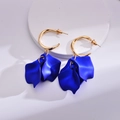 Detailed macro view of elegant deep blue acrylic rose petal earrings on a white stand - Sapphire Blue