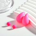 Detail view of neon pink teardrop and ball stud earring set on a white platform - Red
