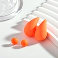 Detail of vibrant orange teardrop resin earrings and ball studs set on display - Orange