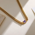 Vintage-Gold-Panzerkette mit rechteckigem lila Zirkon-Anhänger auf Steinhintergrund - Lila