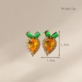 Macro shot of carrot earrings with orange and green stones and white crystal halo - Stud Earrings