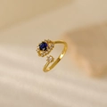 Adjustable gold ring with a sparkling dark blue round gem surrounded by white zircons - Blue Flower Eye Style (JZ004-1)