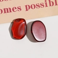 Dettaglio macro di cabochon in resina rosso scuro con effetto occhio di gatto e finitura opaca - Marrone