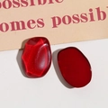 Dettaglio di cabochon in resina rossa ovale con finitura cangiante occhio di gatto - Rosso