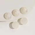 Dettaglio di cinque cabochoni in resina marmorizzata da 16mm per gioielli fai-da-te e clip - Bianco Marmorizzato