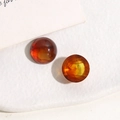 Macro detail of 14mm translucent amber resin cabochons with internal marble swirls - 1 Piece / Amber