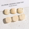 Close-up of 14mm square resin patches with marble texture for DIY jewelry and accessories - Smudged Cream White