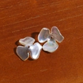 Iridescent three-petal flower resin beads with pearlescent finish on dark wood background - Three Petal Flower Style