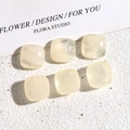 Macro detail of 14mm cream resin square cabochons with elegant marble texture - Ink Translucent White