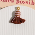 Gros plan de glands en coton marron foncé avec anneaux tressés dorés pour accessoires DIY - Café Foncé