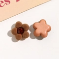Makro-Detail von beflockten Blumenanhängern mit roten Strasssteinen für DIY-Accessoires - Braun