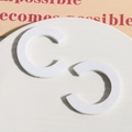 Close-up of matte white C-shaped wooden earring components on a minimalist tray - White
