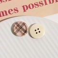 Vista macro de botones redondos de madera de 4 agujeros con estampado de cuadros y crema - Café Rosa