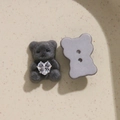 Macro detail of dark grey flocked bear charm with heart zircon and sewing holes back - Gray