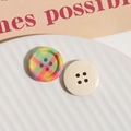 Primer plano de botones de madera a cuadros y crema en un plato para manualidades DIY - Arcoíris