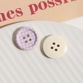 Detalle de botones redondos de madera con cuadros morados y acabado brillante blanco roto - Lavanda