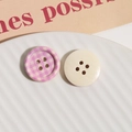 Primer plano de botones de madera a cuadros y lisos en un plato de cerámica para costura DIY - Rosa Rojo