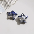 Detalle de botones de tela en forma de estrella con cuadros e insertos de metal - Estilo de Cuadros Azul Blanco Amarillo