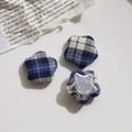 Nahaufnahme von sternförmigen Stoffknöpfen mit blau-gelbem Karomuster und Metallbasis - Schwarz Blau