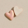 Macro view of pearlescent pink and white heart-shaped resin charms for DIY jewelry making - Pink