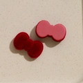 Vue macro d'accessoires de nœuds floqués rouges et roses pour barrettes et chapeaux - Bordeaux