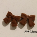 Dettaglio di due fiocchi marroni floccati per fermagli fai-da-te, misura 29x23mm - Fiocco Caffè Scuro