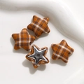 Close-up of star-shaped fabric buttons with orange plaid pattern and metal base - Yellow