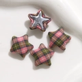 Close-up of star-shaped fabric buttons with pink and green plaid pattern for DIY crafts - Pink