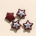 Macro detail of star-shaped faux snakeskin leather patches with silver metal star inlay - Red