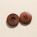 Detalle macro de botones de madera marrón oscuro con grano natural y diseño de cuatro agujeros - 1# Botón Grande (Textura Concéntrica Marrón)