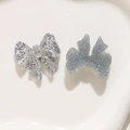 Macro detail of silver glitter bow resin charms for DIY jewelry and accessories crafting - Silver Bowknot