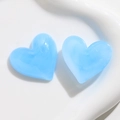 Close-up of heart-shaped acrylic charms in light blue with subtle white water ripples - Blue