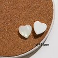Dettaglio di ciondoli a cuore in resina 16mm con finitura in madreperla su sughero - Stile Cuore Piccolo (14x14mm)
