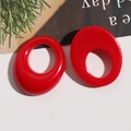 Macro shot of bright red oval resin earrings with smooth polished geometric hollow design - Red