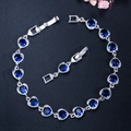 Macro detail of silver heart bracelet with blue crystals and folding clasp extension - Blue