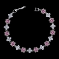 Détail du bracelet en argent avec pierres roses et fleurs blanches sur fond noir élégant - Rose