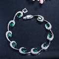 Detailopname van een zilveren armband met smaragdgroene stenen en zirkonia kristallen - Groen