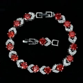 Macro shot of silver-plated bracelet featuring red round zircon and folding clasp detail - Red